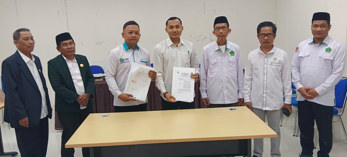 Perwakilan KPI UI DDI dan KPI STAIN Majene menunjukkan dokumen kerja sama